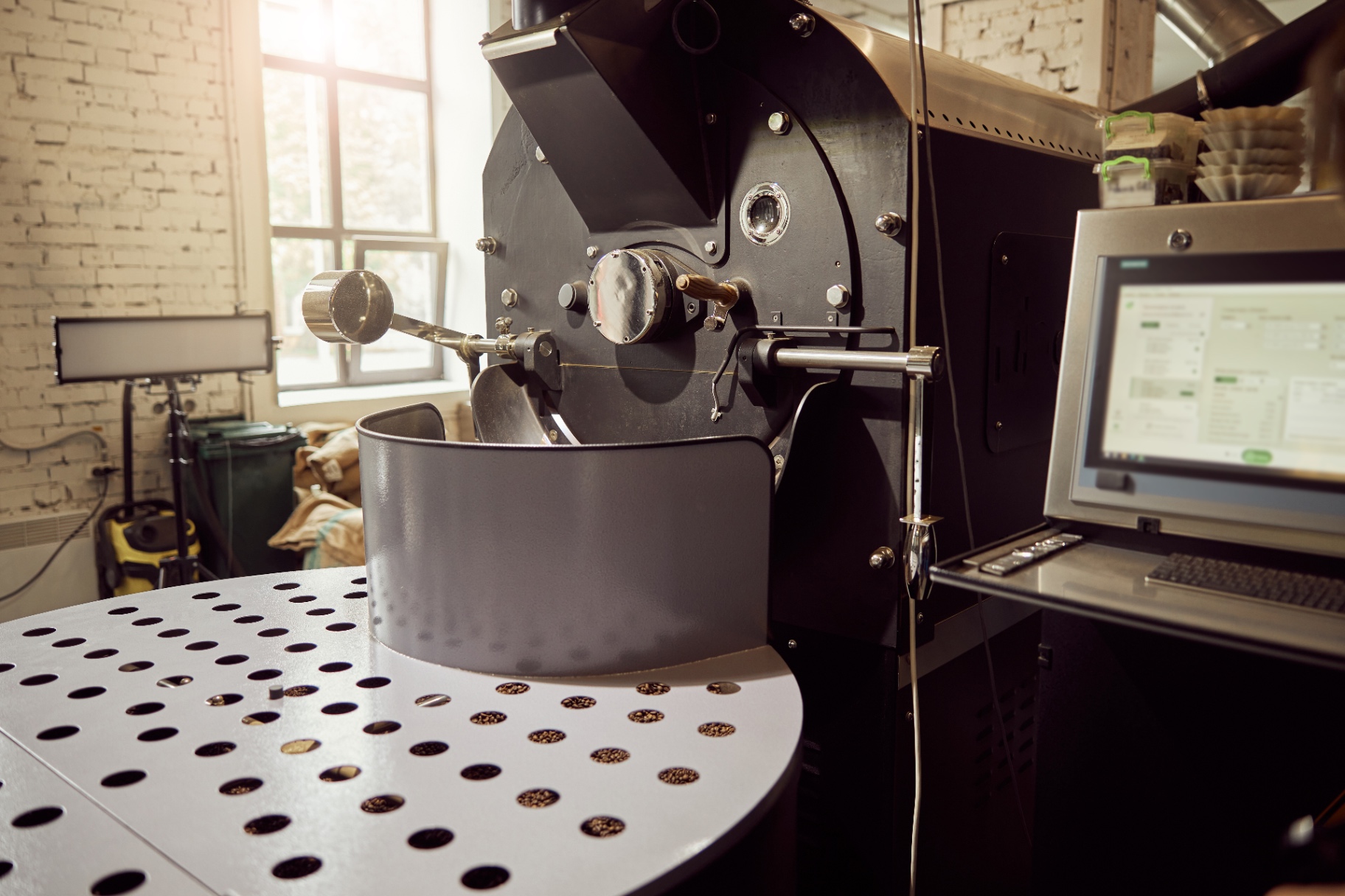 Coffee roaster with beans on the perforated cooling table